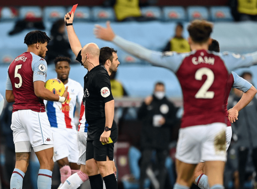 Referee Anthony Taylor showing a red card after reviewing the incident on the VAR monitor