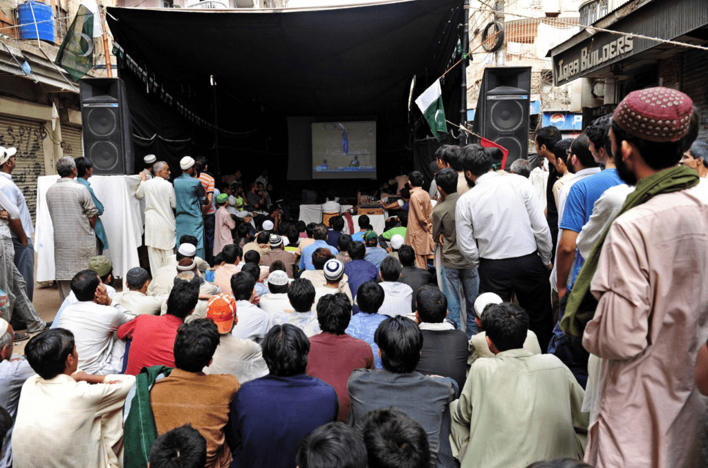 Cricket fans holding Indian and Pakistani flags during a high-stakes ICC match